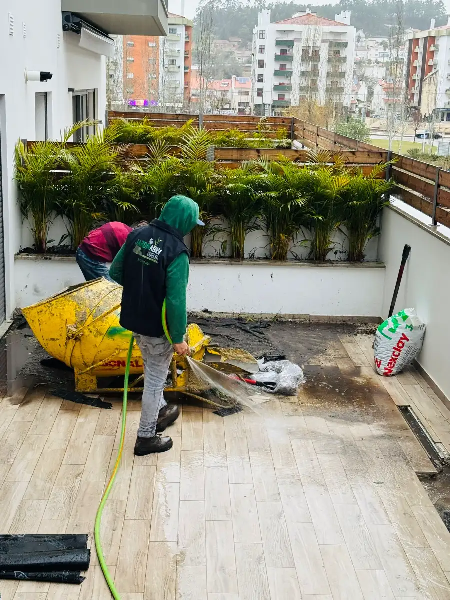 Técnico da Jardinagem Coelho a lavar o terraço e a regar as floreiras de um empreendimento