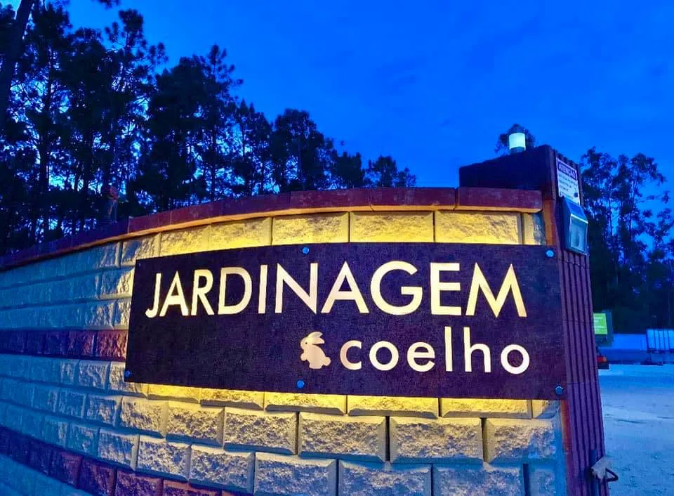 Letreiro iluminado da Jardinagem Coelho ao entardecer
