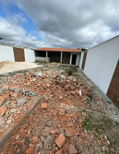 Quintal de moradia com relva sintética e canteiros — durante a obra