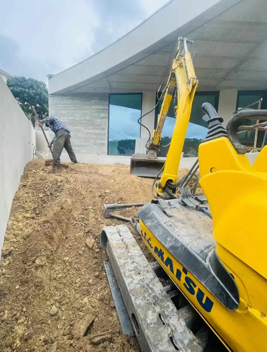 Técnico a nivelar o terreno junto à mini-giratória, durante a obra