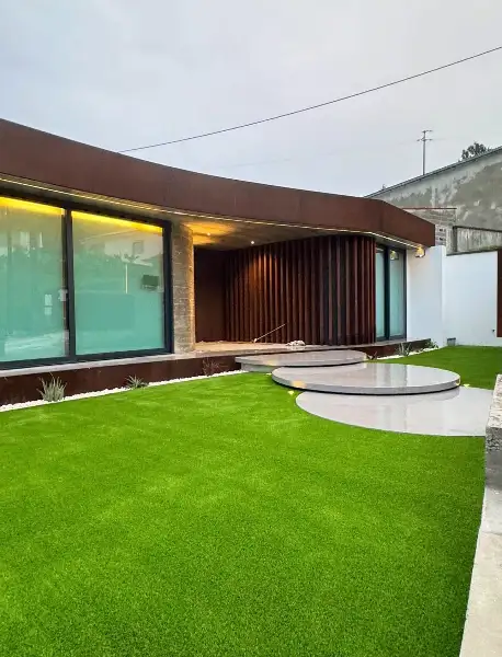 Jardim de moradia contemporânea com relva sintética e pátio interior — resultado final
