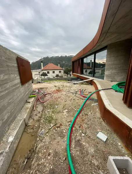 Jardim de moradia contemporânea com relva sintética e pátio interior — durante a obra