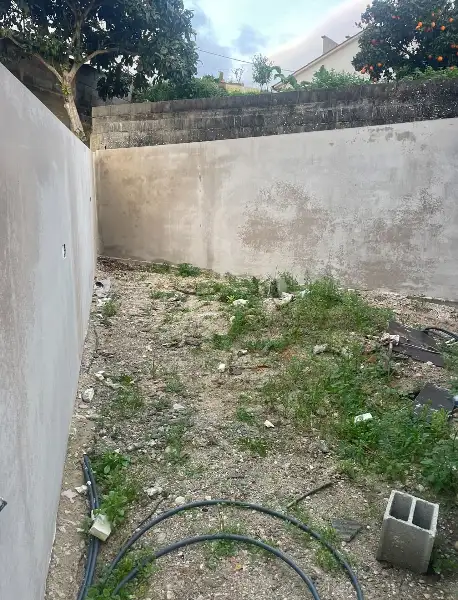 Jardim de moradia contemporânea com relva sintética e pátio interior — durante a obra