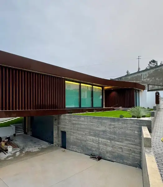 Jardim de moradia contemporânea com relva sintética e pátio interior — durante a obra