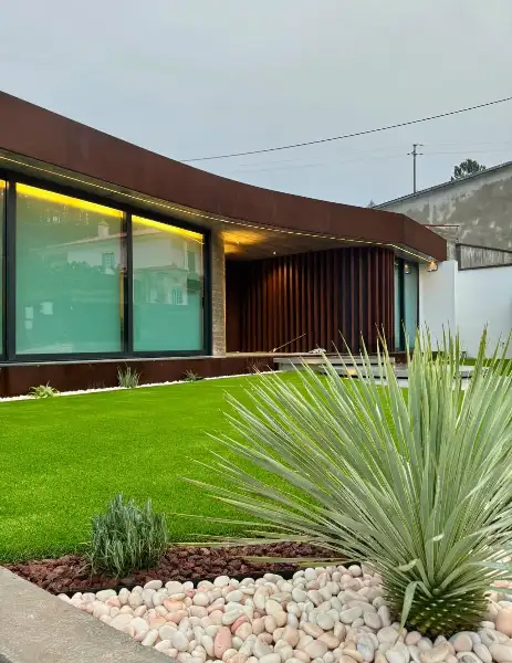 Jardim de moradia contemporânea com relva sintética e pátio interior — resultado final
