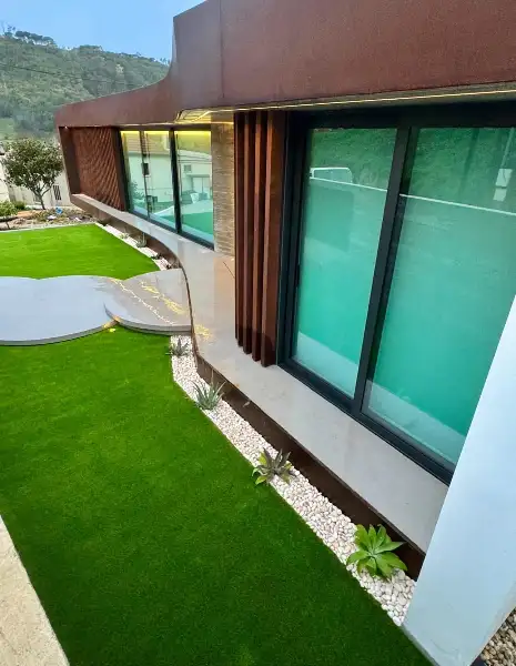 Jardim de moradia contemporânea com relva sintética e pátio interior — resultado final
