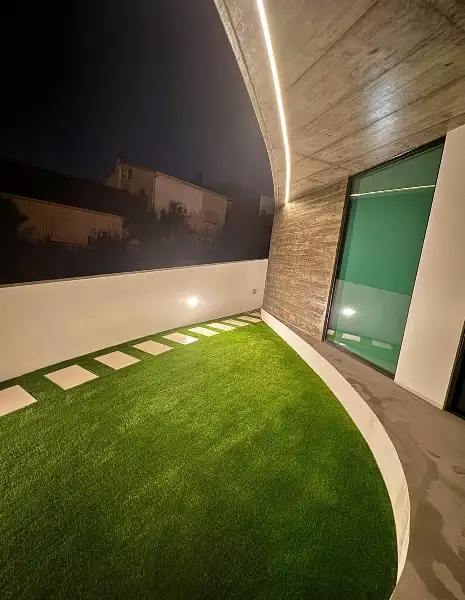 Jardim de moradia contemporânea com relva sintética e pátio interior — resultado final