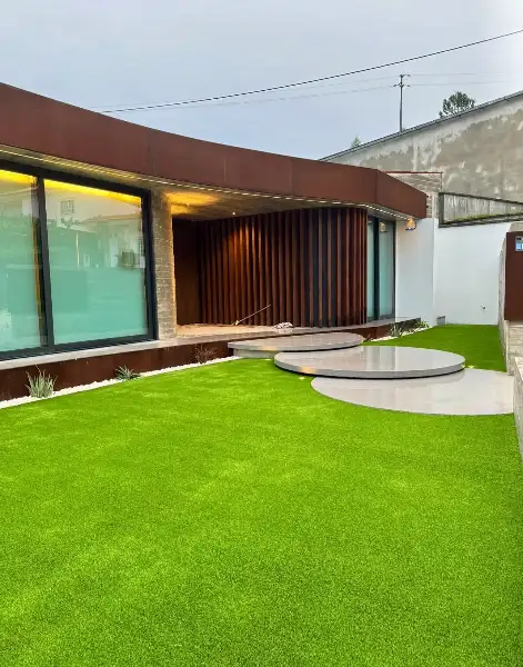 Jardim de moradia contemporânea com relva sintética e pátio interior — resultado final