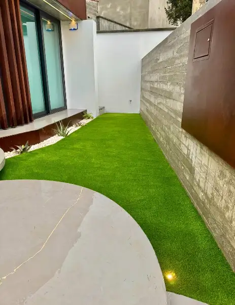Jardim de moradia contemporânea com relva sintética e pátio interior — resultado final