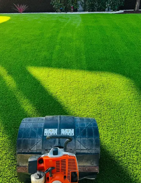 Jardim de moradia com palmeiras, seixo branco e relva sintética — durante a obra