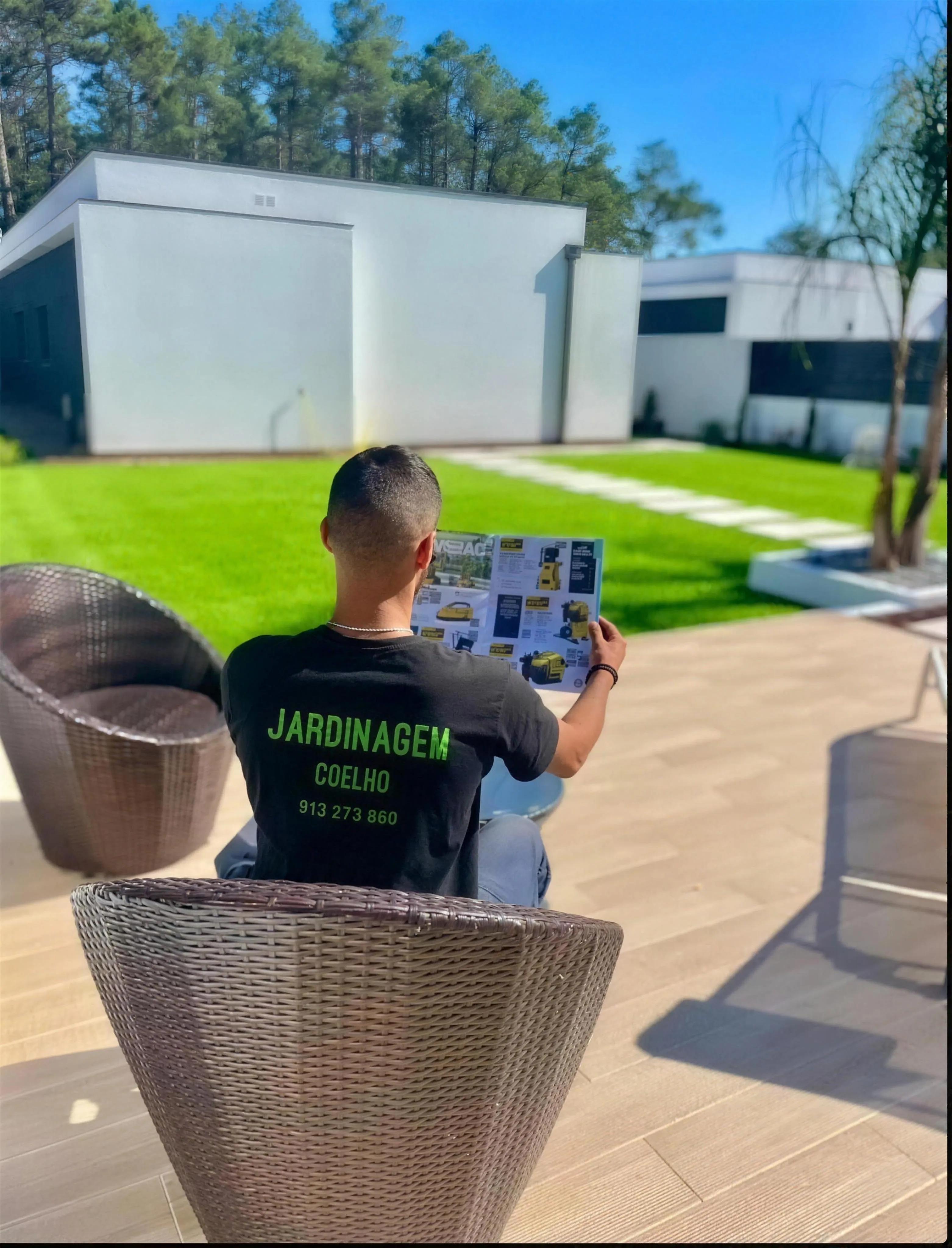 Jardim amplo com relva sintética, caminhos em lajes e zona de fogueira