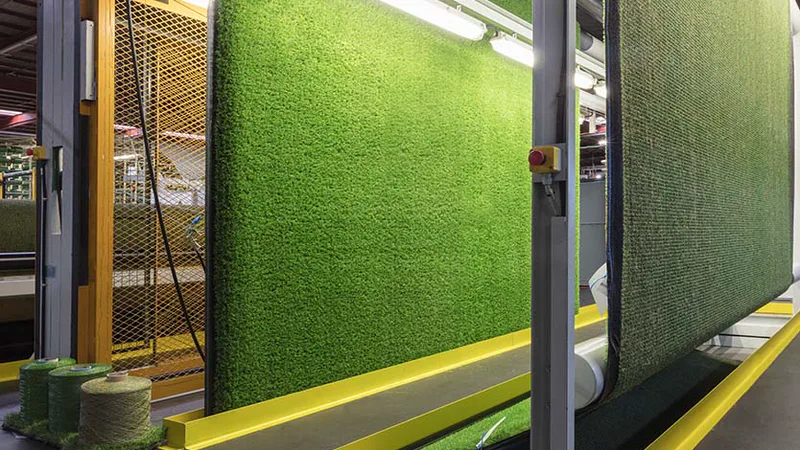 Rolos de relva sintética numa linha de produção da fábrica Turfgrass