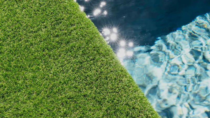Relva sintética Turfgrass a rematar o bordo de uma piscina com a água a brilhar ao sol